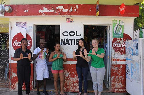 (L-R) SBA student Briana Scott represents the U with the group’s translator and a small business owner to her left, with student Riva Trevedi and Nancy Hullihen, executive director of alumni relations and development at the School of Business Administration.